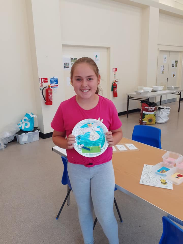 child with paper plate drawing